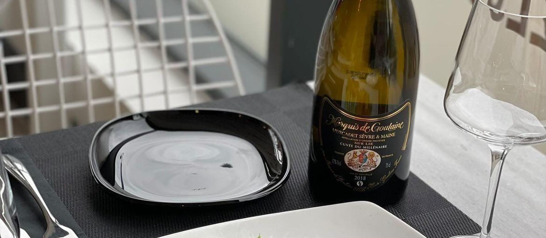 A laid table with plated seafood, glasses and wine