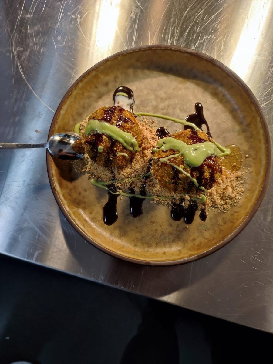 Plated dish finished with herb oil and aged balsamic